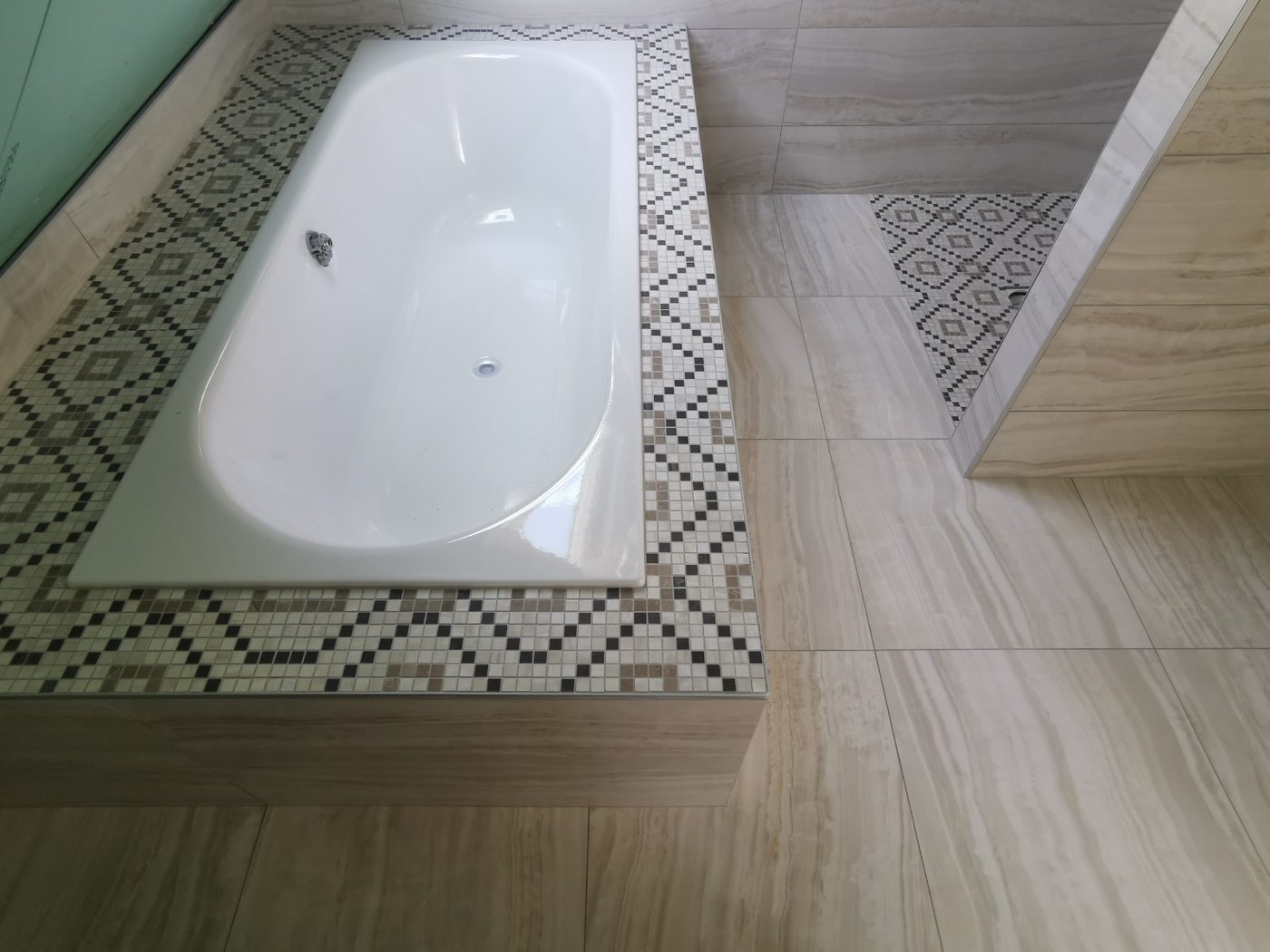 Baignoire encastrée avec encadrement mosaïque et carrelage imitation pierre, salle de bain rénovée à Villard-de-Lans