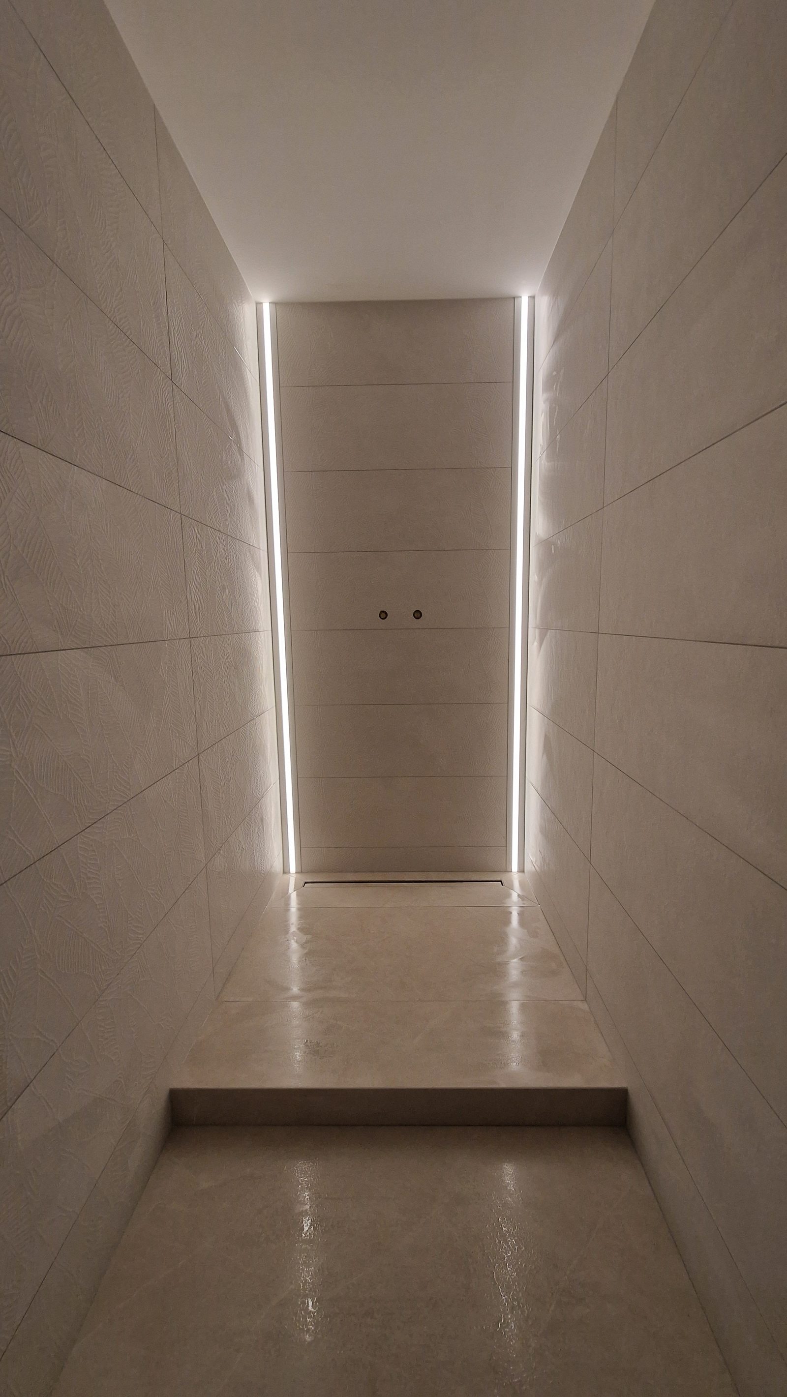 Douche à l'italienne avec LED intégrées dans le carrelage, finition contemporaine épurée