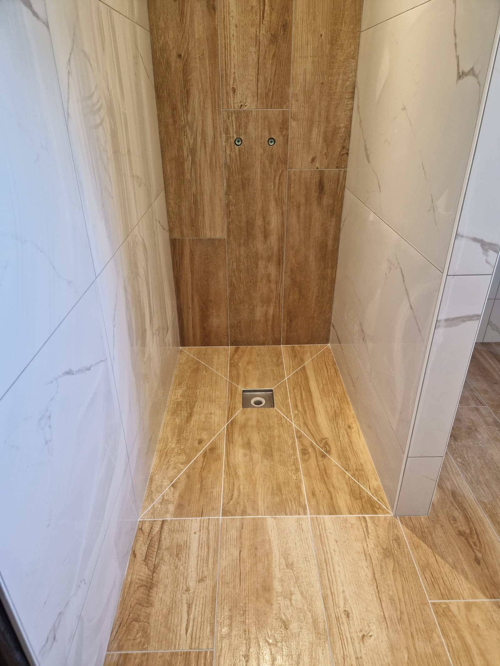 Salle de bain avec carrelage effet marbre blanc et effet bois, finition haut de gamme, posée par SR Carrelage