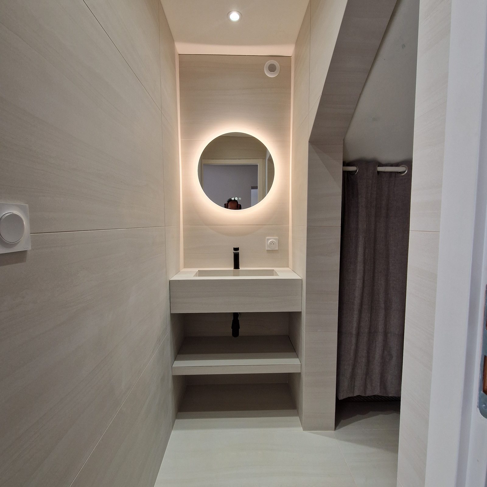 Cabinet de toilette moderne avec vasque carrelée sur mesure et miroir LED rond