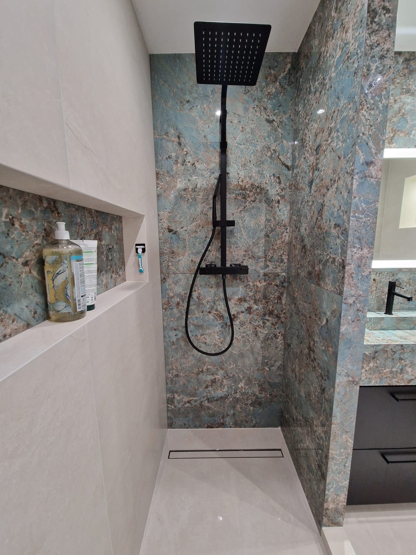 Douche italienne avec carrelage effet marbre vert et robinetterie noire, chalet du Vercors