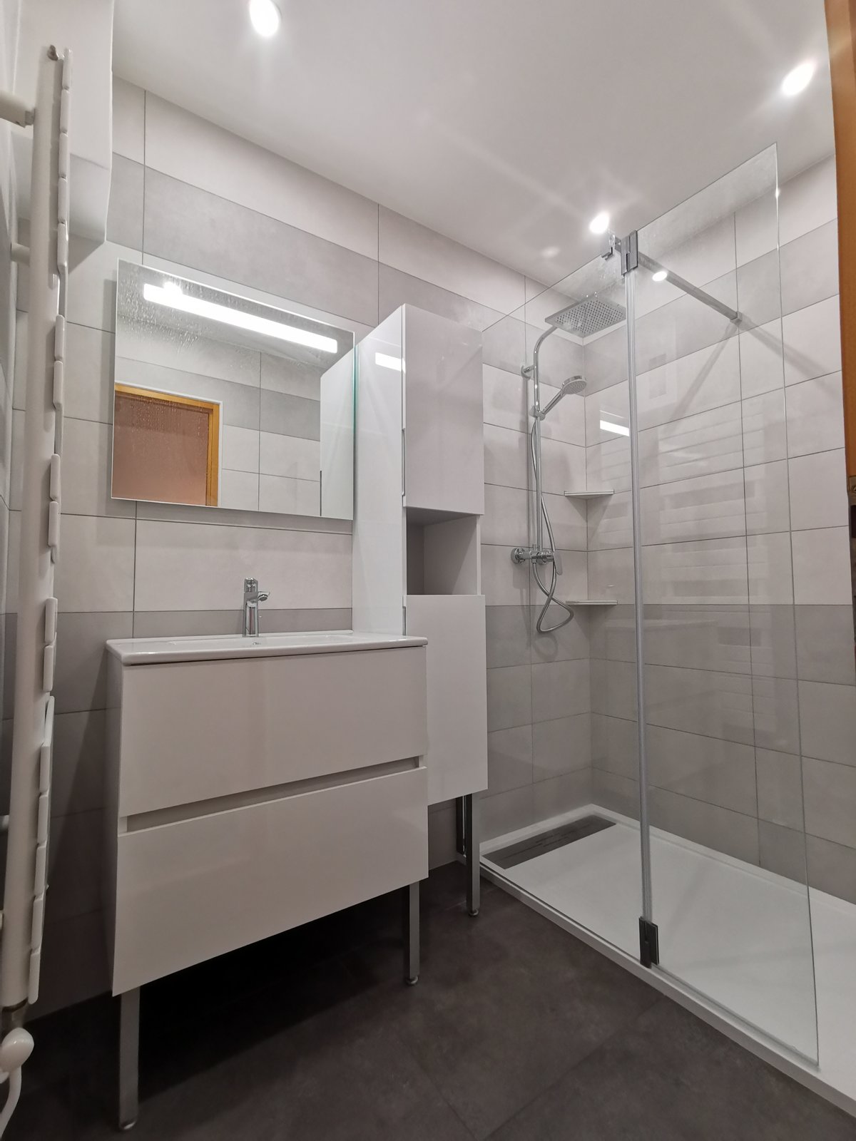 Après : salle de bain blanche moderne avec vasque suspendue, douche italienne, paroi vitrée transparente