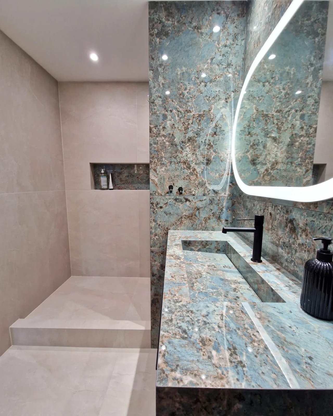 Détail vasque carrelée marbre bleu Florim avec faux fond cachant l'écoulement, robinetterie murale noire