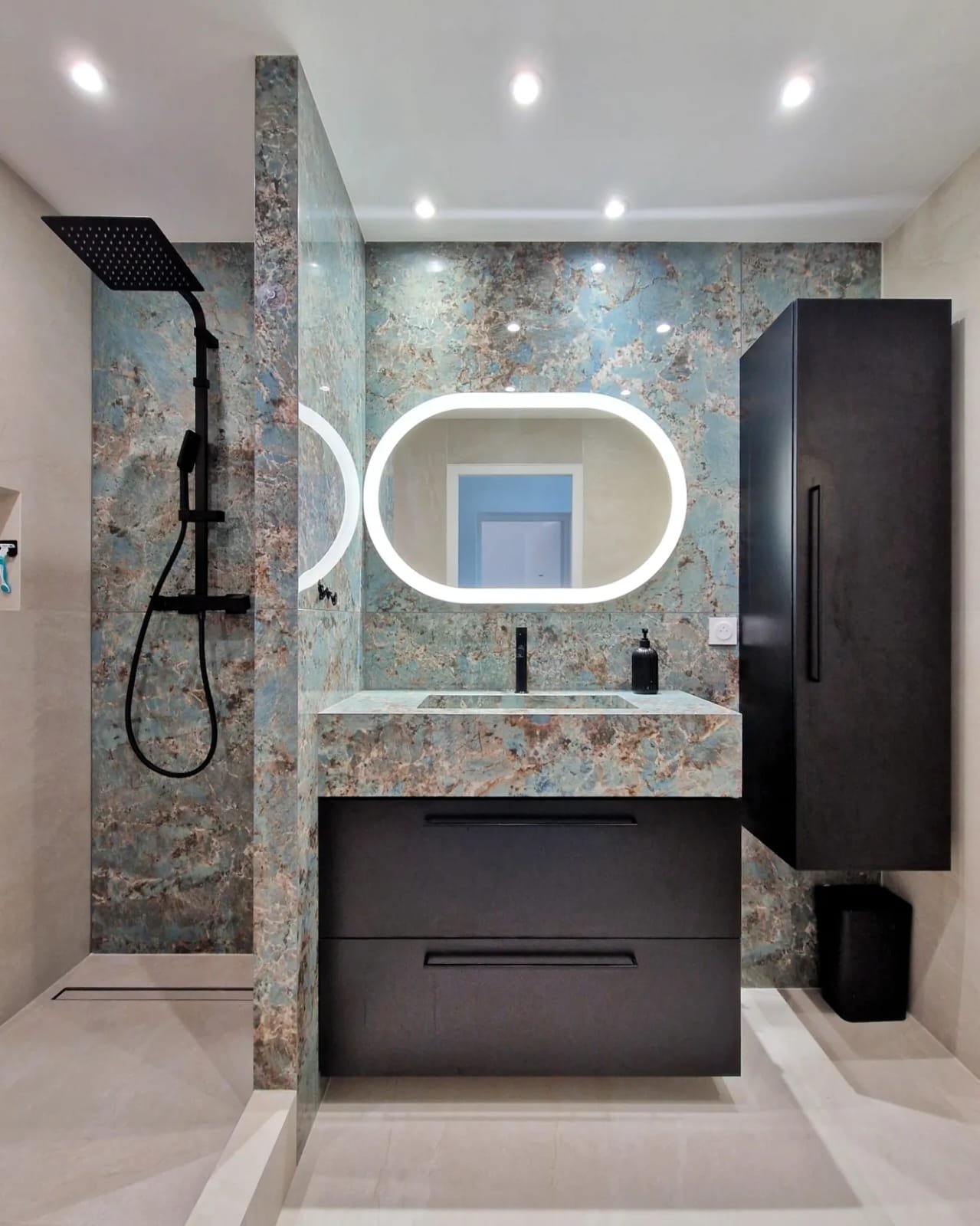 Vue large de salle de bain avec vasque en carrelage marbre bleu Florim, paroi de douche et miroir LED