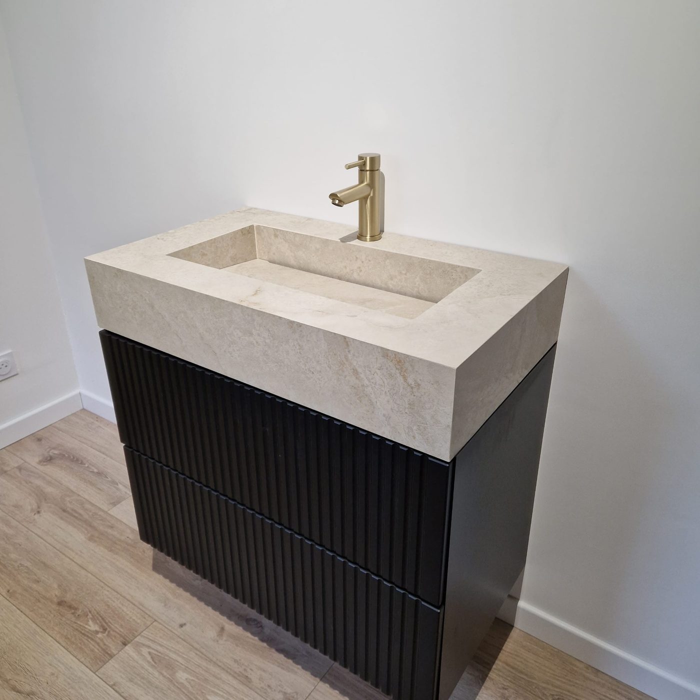 Vasque effet travertin sur meuble cannelé noir, salle de bain contemporaine réalisée dans le Vercors